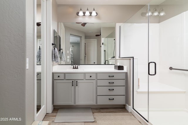 bathroom with a shower with door, vanity, and hardwood / wood-style floors