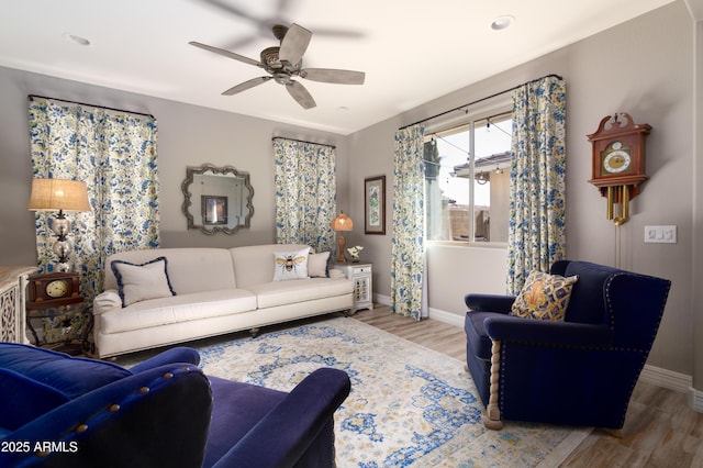 living room with wood-type flooring and ceiling fan