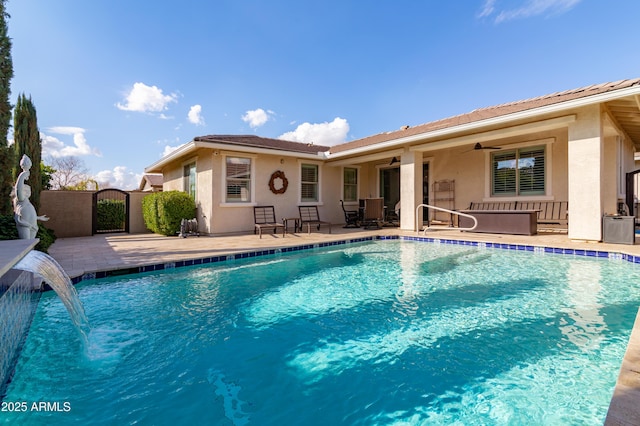 view of pool with pool water feature, ceiling fan, and a patio area