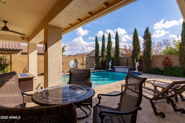 view of swimming pool featuring pool water feature, ceiling fan, an outdoor fire pit, and a patio