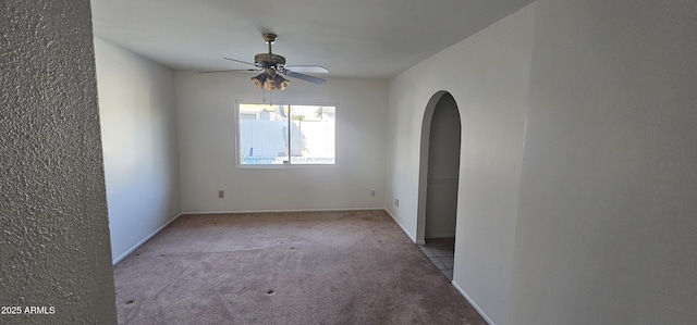 empty room featuring ceiling fan and light colored carpet