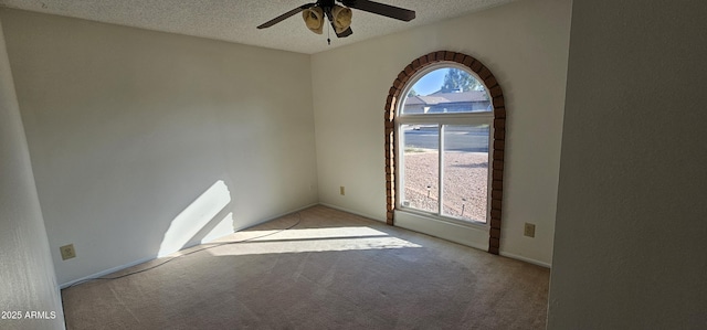 carpeted spare room with ceiling fan and a textured ceiling