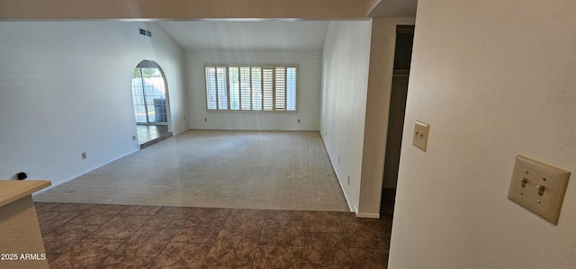 carpeted spare room with lofted ceiling