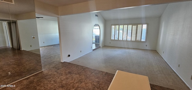 carpeted spare room featuring lofted ceiling