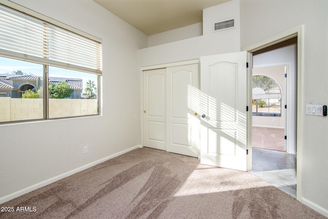 unfurnished bedroom featuring light carpet and a closet