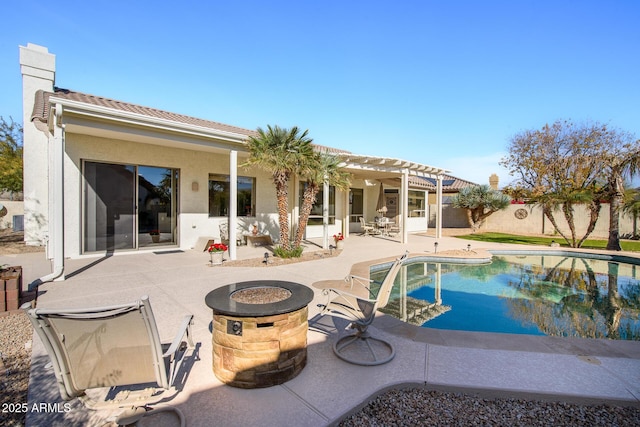 rear view of house with a fire pit and a patio