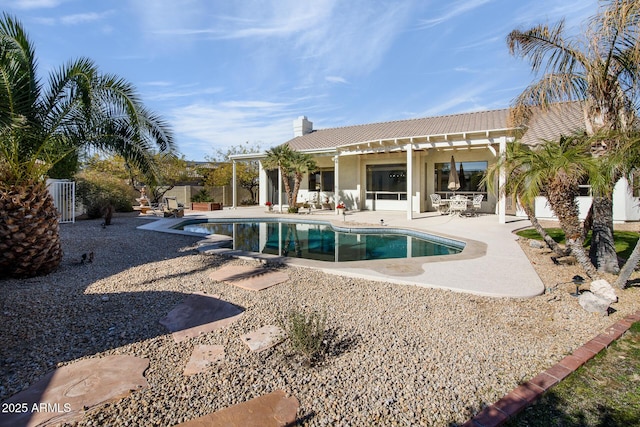 rear view of house with a tile roof, fence, a fenced in pool, a pergola, and a patio area