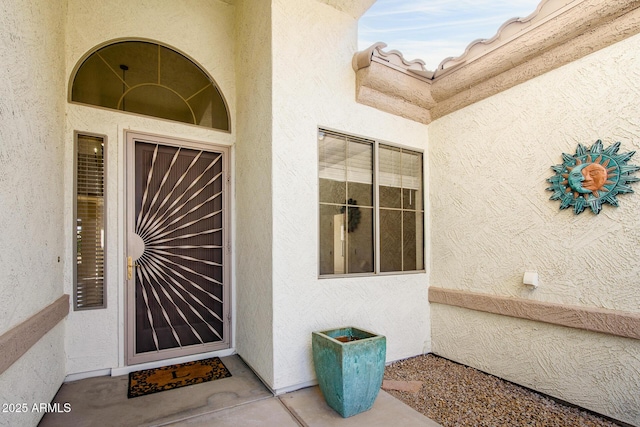 entrance to property featuring stucco siding