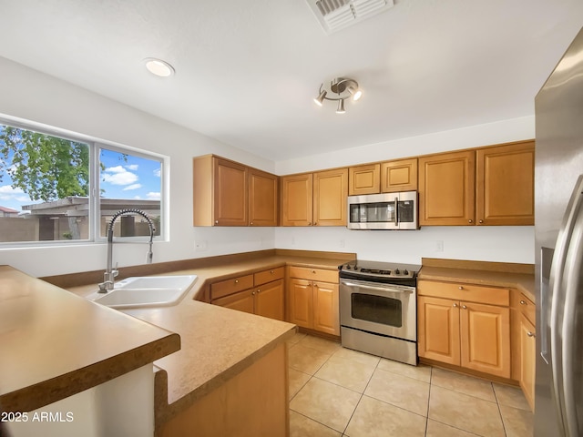 1078 E Poncho Ln, San Tan Valley, AZ 85143 - kitchen with appliances with stainless steel finishes, a sink, light tile patterned flooring, and a peninsula