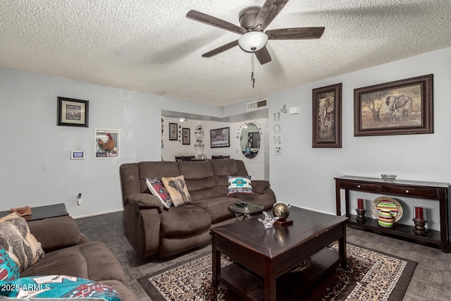 living room with dark parquet flooring, a textured ceiling, and ceiling fan