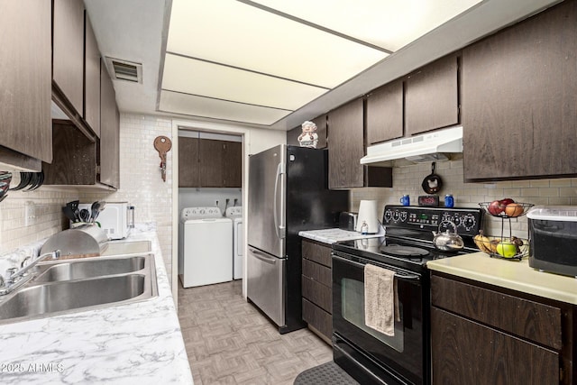 kitchen featuring black electric range oven, sink, stainless steel fridge, separate washer and dryer, and light parquet flooring