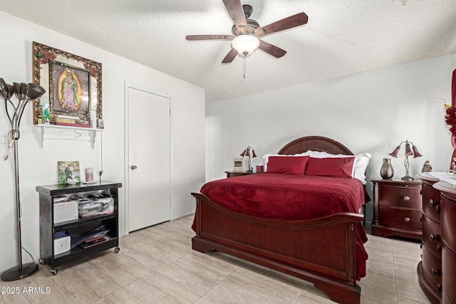 bedroom with ceiling fan and a textured ceiling