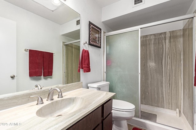 bathroom with vanity, an enclosed shower, and toilet