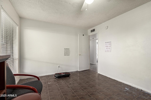 sitting room with ceiling fan and a textured ceiling