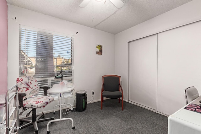 office featuring ceiling fan, a textured ceiling, and dark colored carpet