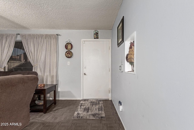 foyer featuring a textured ceiling and dark parquet floors