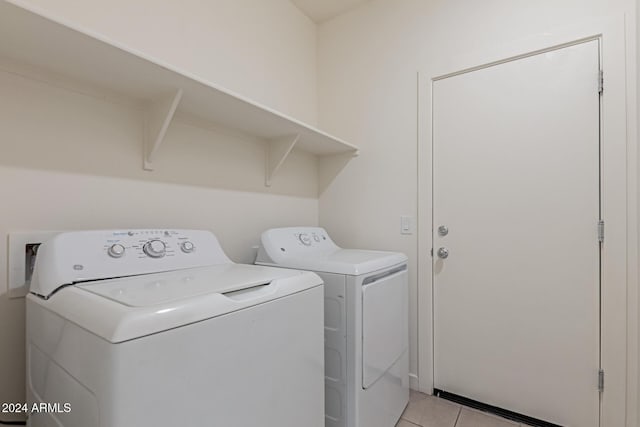 laundry area with light tile patterned flooring and washing machine and clothes dryer