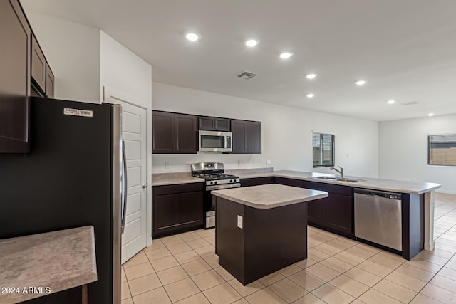 kitchen featuring appliances with stainless steel finishes, light tile patterned floors, a kitchen island, and sink