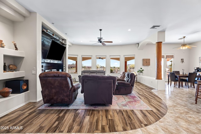 living area featuring recessed lighting, decorative columns, a ceiling fan, visible vents, and wood finished floors