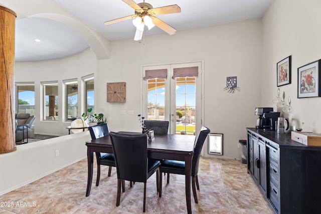 dining room with arched walkways, ceiling fan, and a wealth of natural light