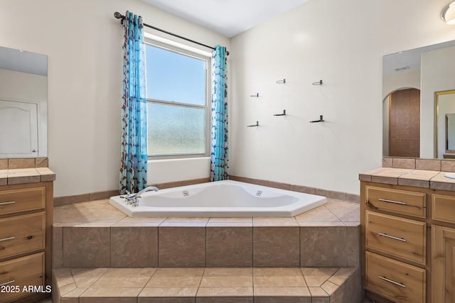 bathroom with visible vents, vanity, and a bath