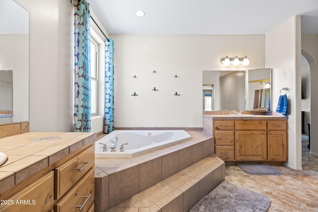 bathroom with vanity and a bath
