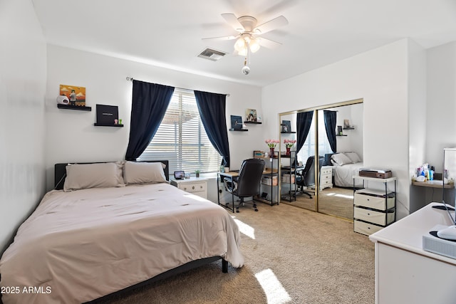 bedroom with visible vents, ceiling fan, a closet, and light colored carpet