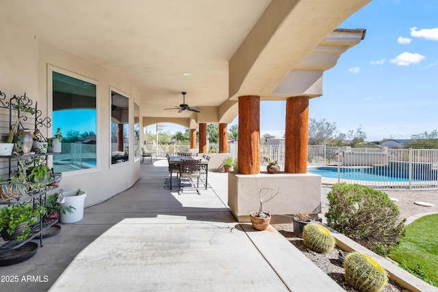 view of patio featuring ceiling fan, fence, outdoor dining area, and a fenced in pool
