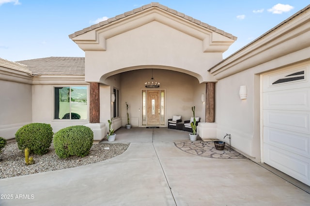 property entrance featuring a garage and stucco siding