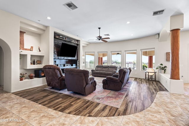 living room featuring a ceiling fan, visible vents, and wood finished floors