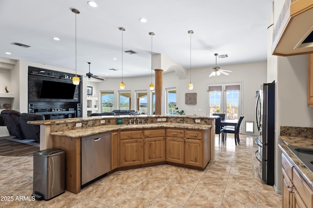 kitchen featuring appliances with stainless steel finishes, open floor plan, ceiling fan, and a sink