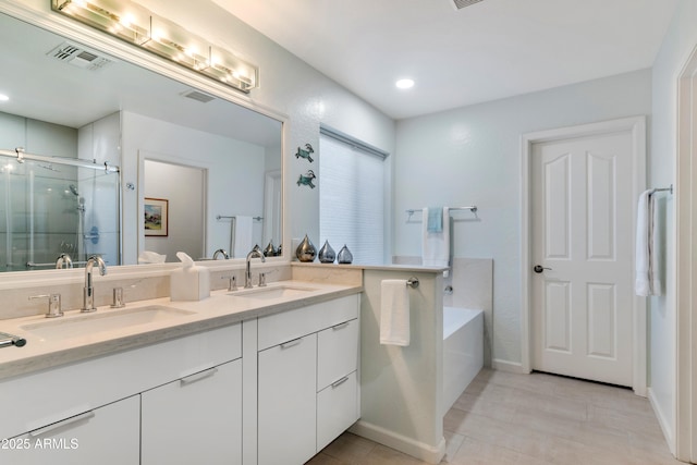 bathroom with a sink, a shower stall, double vanity, and visible vents