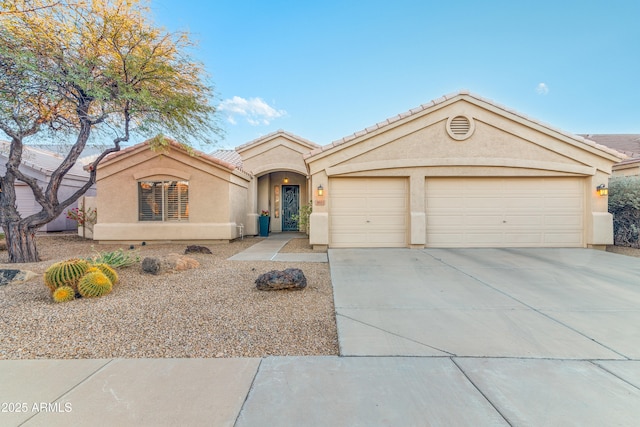 mediterranean / spanish-style home with stucco siding, driveway, a tile roof, and a garage