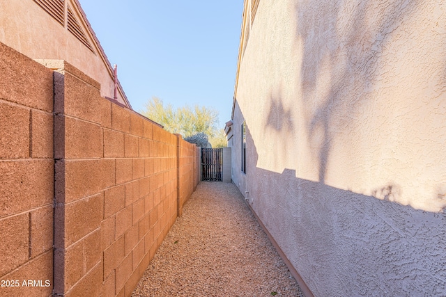 view of side of property with fence and stucco siding