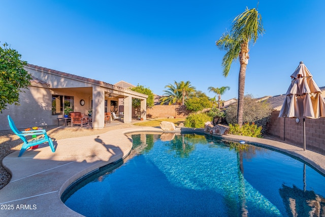 outdoor pool featuring a fenced backyard, a ceiling fan, and a patio area
