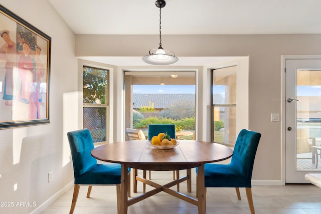 dining room with light tile patterned floors, baseboards, and a wealth of natural light