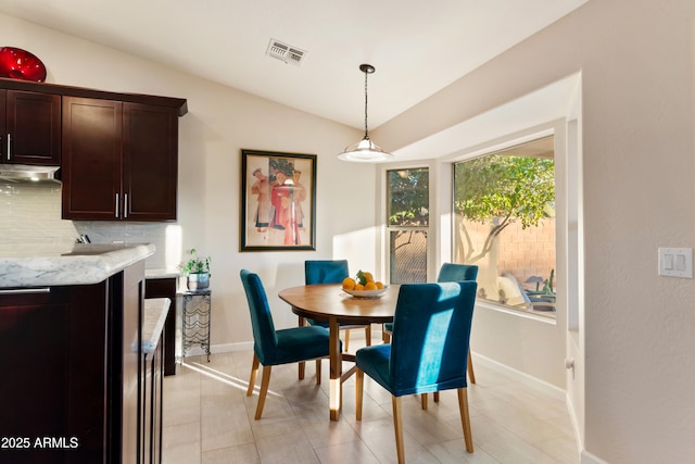dining space featuring visible vents, baseboards, and lofted ceiling