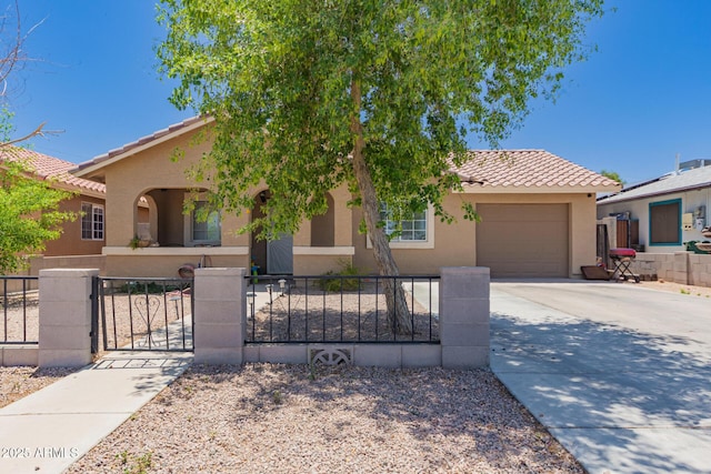 503 W 11th St, Casa Grande, AZ 85122 - mediterranean / spanish-style home featuring a tiled roof, stucco siding, a garage, a fenced front yard, and driveway
