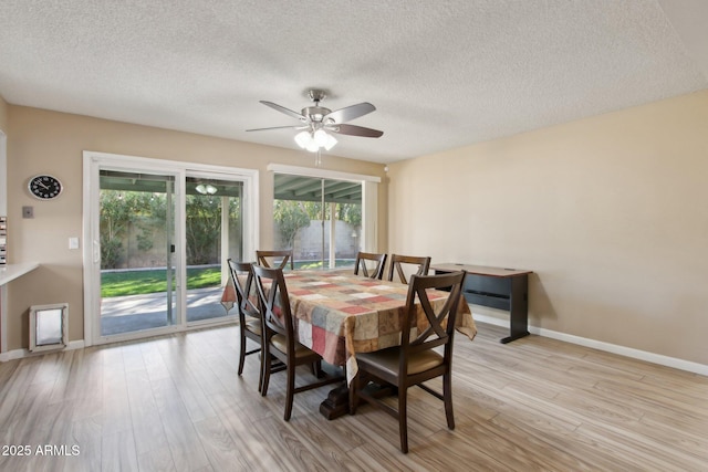 dining area with a wealth of natural light, baseboards, light wood-style flooring, and ceiling fan