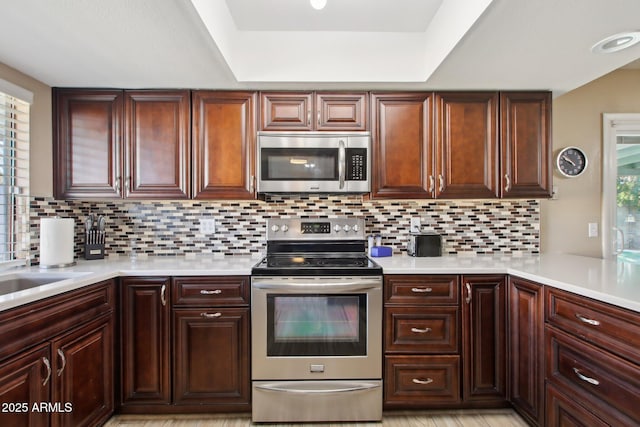 kitchen featuring light countertops, backsplash, and stainless steel appliances