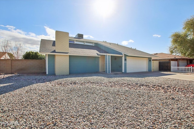 view of front facade featuring a shingled roof, fence, cooling unit, a garage, and driveway