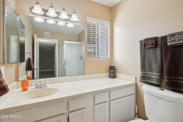 bathroom with vanity, toilet, visible vents, and a stall shower