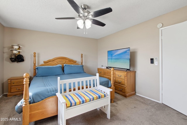 bedroom with baseboards, a textured ceiling, carpet, and a ceiling fan