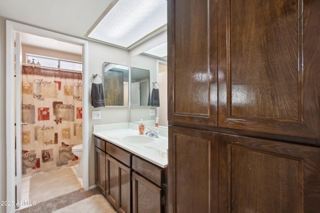 bathroom with a shower with shower curtain, toilet, vanity, and tile patterned floors