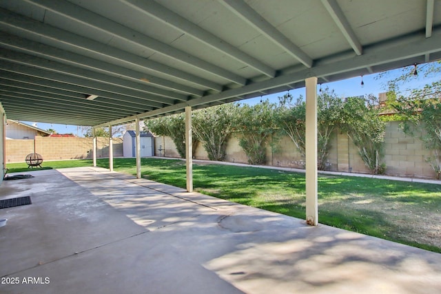 view of patio / terrace featuring a storage shed, a fenced backyard, and an outdoor structure