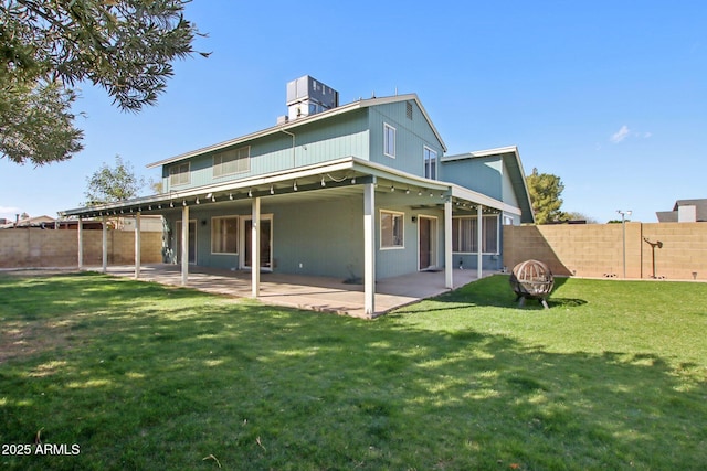 back of property featuring a yard, a patio, and a fenced backyard