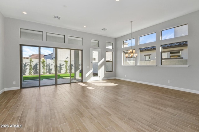 unfurnished room featuring wood-type flooring and a chandelier