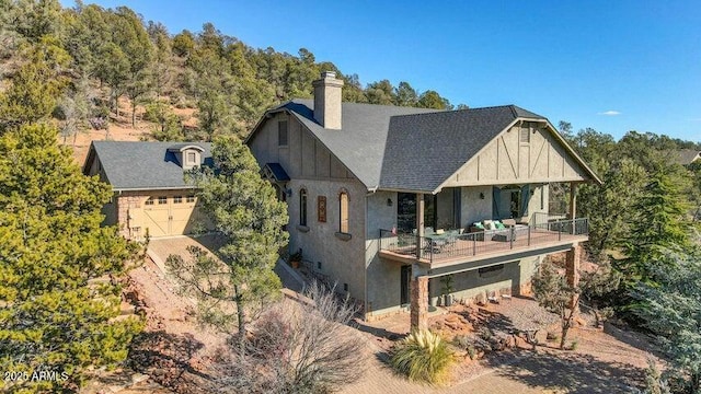 back of house with a garage and a balcony