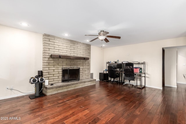 living area featuring wood finished floors, a ceiling fan, a brick fireplace, baseboards, and recessed lighting