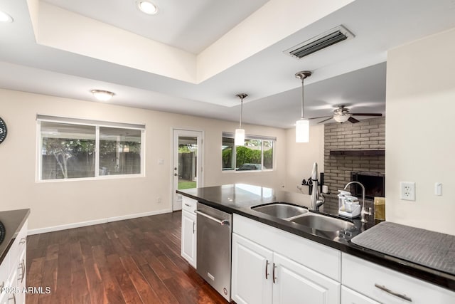 kitchen with a ceiling fan, a sink, stainless steel dishwasher, visible vents, and dark wood-style flooring